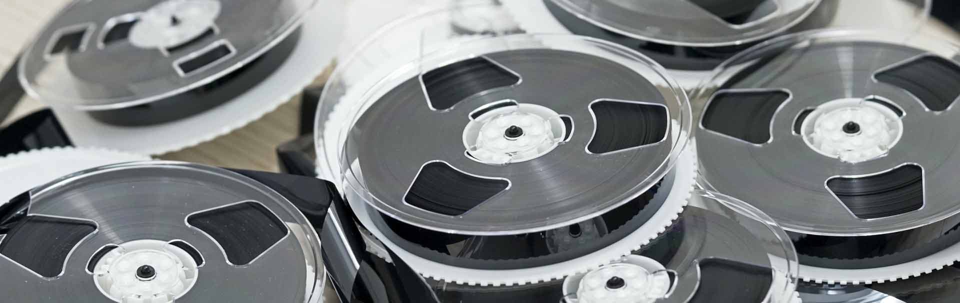 Närbild på olika gamla videoband (VHS, Hi8) som väntar på konvertering till digitalt format.